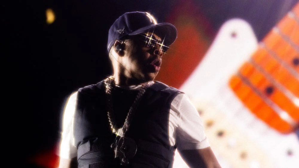 Jay-Z de boné e óculos brilhantes durante um show