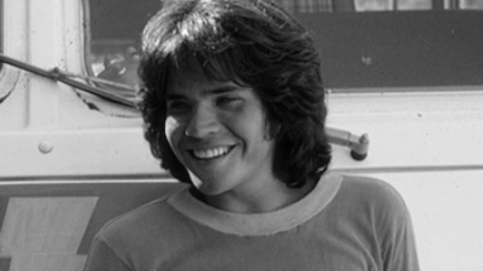 Michael Gray jovem, sorrindo, em foto em preto e branco